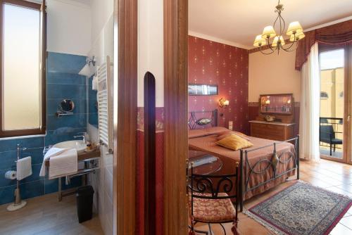 ein Bad mit einem Bett und einem Waschbecken in einem Zimmer in der Unterkunft Pinto-Storey Hotel in Neapel