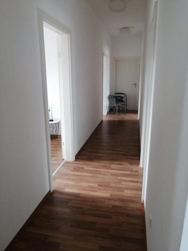 an empty hallway with white walls and wood floors at Wohnung mit 5 Zimmern für bis zu 10 Personen in Amstetten