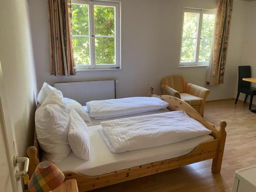 two beds in a room with two windows at Gasthaus Lamm in Waldenbuch