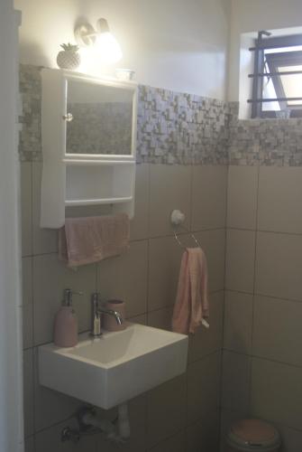 baño con lavabo, ventana y aseo en Villa Le Mahé en Beau Vallon