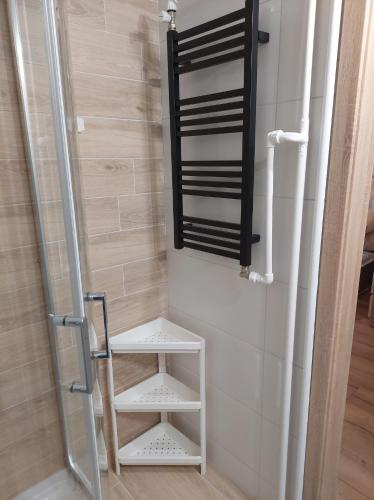 uma casa de banho com um espelho e uma prateleira branca em Apartament na Reja em Olkusz