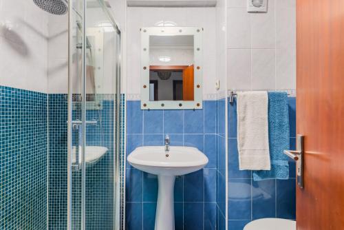 a blue and white bathroom with a sink and a shower at Mira-Ria - Apartamento em bairro calmo e central in Aveiro