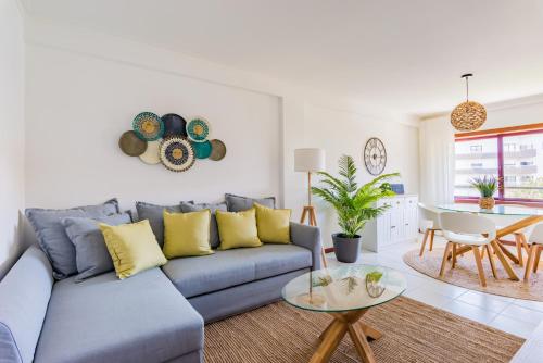 a living room with a blue couch and a table at Mira-Ria - Apartamento em bairro calmo e central in Aveiro