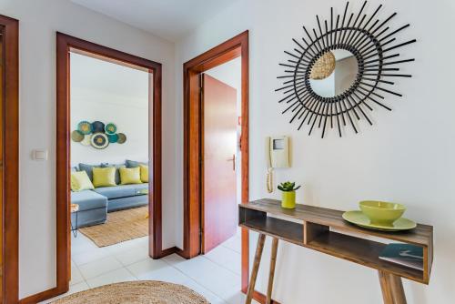 a living room with a table and a mirror at Mira-Ria - Apartamento em bairro calmo e central in Aveiro