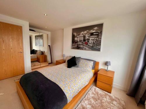 Lovely City Centre 1 bed apartment في Beeston Hill: غرفة نوم بسرير كبير وغرفة بها أريكة