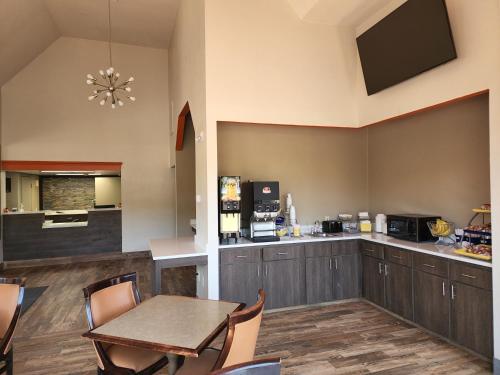 クレムゾンにあるDays Inn by Wyndham Clemsonのテーブルとキッチンのあるダイニングルーム