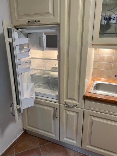 einem leeren Kühlschrank mit offener Tür in der Küche in der Unterkunft Hummelglück - Ferienwohnung mit Terrasse in 30 Min in HH City in Bendestorf