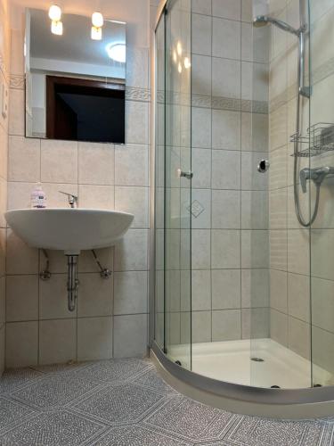 ein Bad mit einem Waschbecken und einer Dusche in der Unterkunft Hummelglück - Ferienwohnung mit Terrasse in 30 Min in HH City in Bendestorf