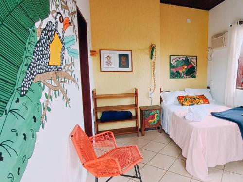 1 dormitorio con 1 cama, mesa y sillas en Pousada Lira Praieira Paraty en Paraty