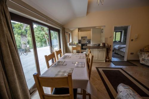 a dining room with a table and chairs and a kitchen at The Larches in Bewdley