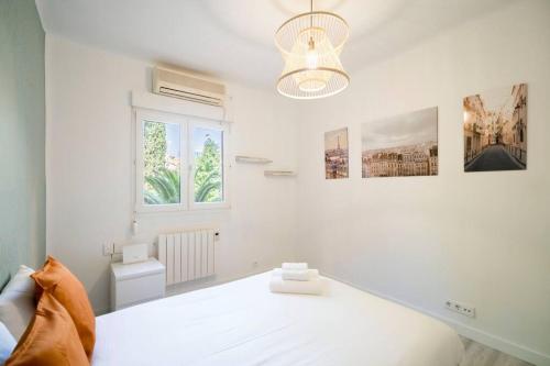 a white bedroom with a bed and a window at Acogedor apartamento. Arturo Soria-MD Anderson 1E in Madrid