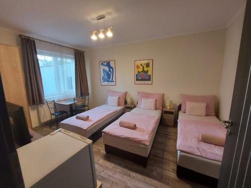 Habitación de hotel con 2 camas y mesa en Borostyán Panzió en Debrecen