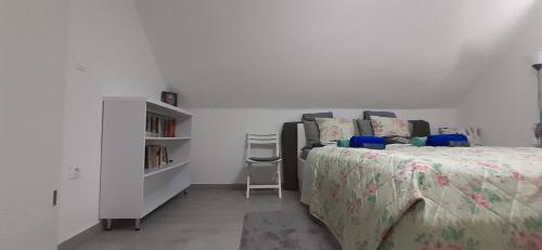 a bedroom with a bed and a book shelf at Apartman for You in Gyenesdiás