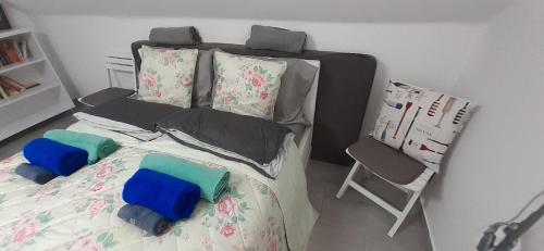 a bed with two pillows and a chair in a room at Apartman for You in Gyenesdiás