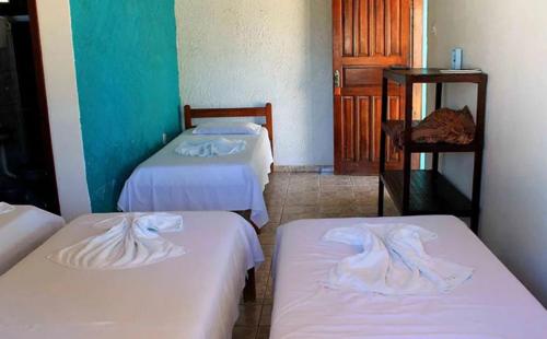 Zimmer mit 3 Betten und weißer Bettwäsche in der Unterkunft Pousada Ilha do Desejo in Olivença