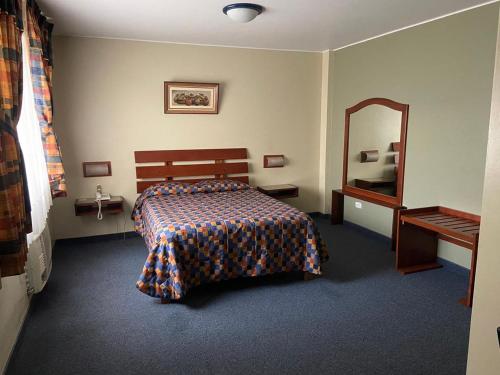 a bedroom with a bed and a mirror at Los Mirtos suite & Hotel in Lima