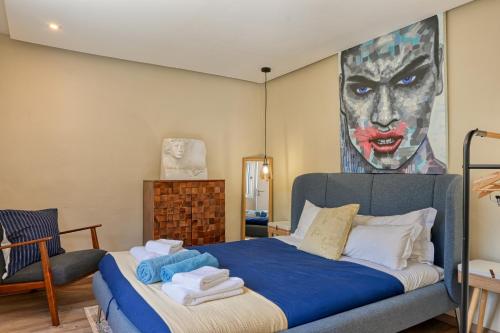 ein Schlafzimmer mit einem Bett und einem Gemälde an der Wand in der Unterkunft Villa Santa Madalena, a Home in Madeira in Arco da Calheta