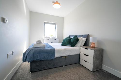 a bedroom with a large bed with a blue blanket at Rooftop Apartment At Queens Beautiful views in Belfast