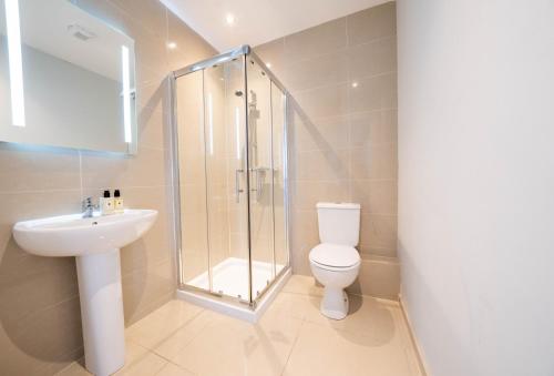 uma casa de banho com um chuveiro, um WC e um lavatório. em Three bed apartment sleeps 5 in botanic em Belfast