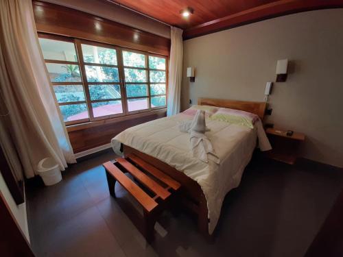 Un dormitorio con una cama grande y una ventana en Hotel Heidinger, en Oxapampa