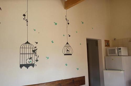 una cocina con aves y una jaula en la pared en Cabañas Las Nanys en Balneario Claromecó