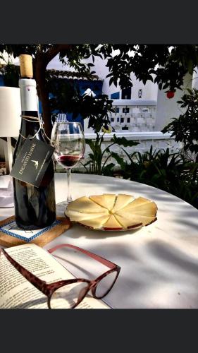 a table with a bottle of wine and a glass at Palacete Encanto Maior in Campo Maior