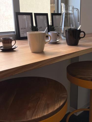 four coffee cups sitting on a wooden table at Lo Studio in Millesimo