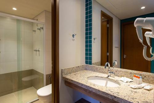 a bathroom with a sink and a shower and a toilet at Solar das Águas Park Resort in Olímpia