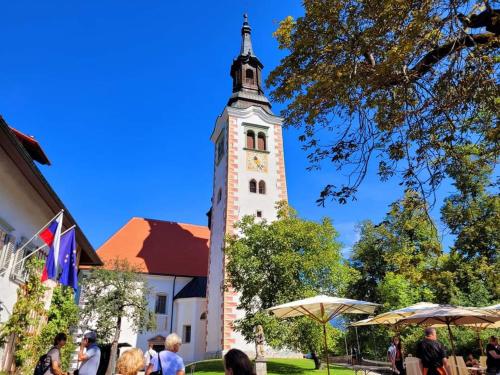 a tall tower with a clock on a building at Apartments Karin in Bled