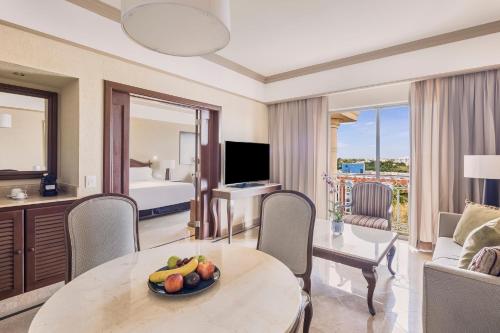 a hotel room with a table with a bowl of fruit on it at Fiesta Americana Merida in Mérida