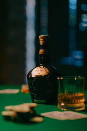 a bottle of alcohol next to a glass on a table at Mtserlebi Resort in K'vishkhet'i