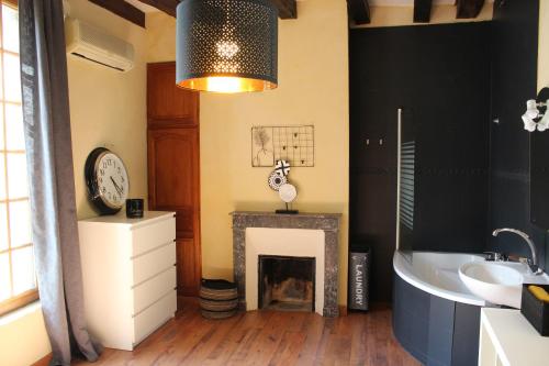 La salle de bains est pourvue d'une cheminée, d'une horloge et d'une baignoire. dans l'établissement Superbe Appartement historique Rue Colbert, à Tours