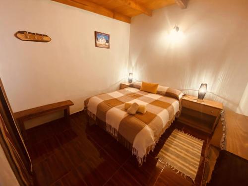 a bedroom with a bed with two lamps on it at Hostal Katari in San Pedro de Atacama