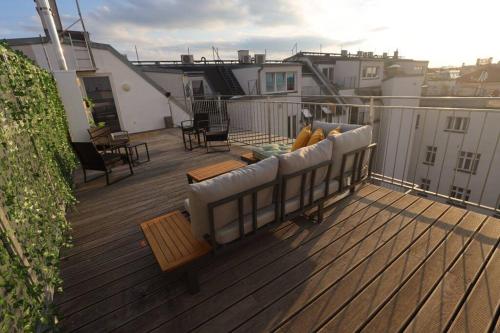 un divano sul ponte di un balcone di Sunny & large Penthouse with View above Vienna DG6 a Vienna