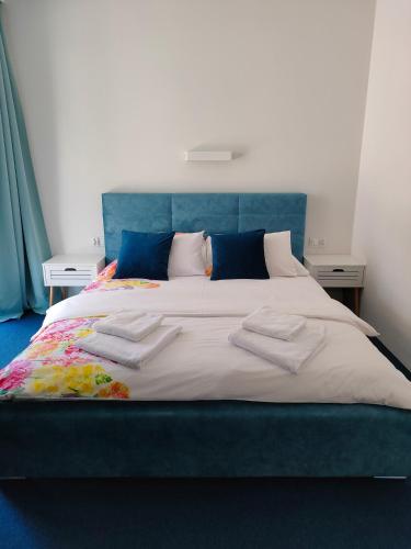 a large bed with two white towels on it at Apartamenty Mistral in Jastarnia