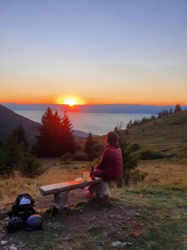 a person sitting on a bench watching the sunset at Chalet Chalon in Meillerie