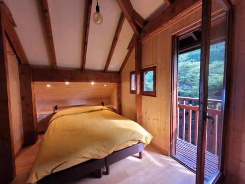 uma cama num quarto com uma grande janela em Chalet Chalon em Meillerie