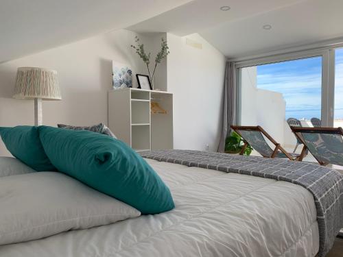 - une chambre avec 2 lits avec un oreiller bleu dans l'établissement Barardo Street, à Baleal