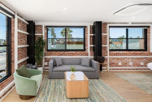 a living room with a couch and a brick wall at The Brick Boutique Hotel in Oceanside