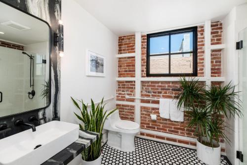 a bathroom with a white sink and a brick wall at The Brick Boutique Hotel in Oceanside