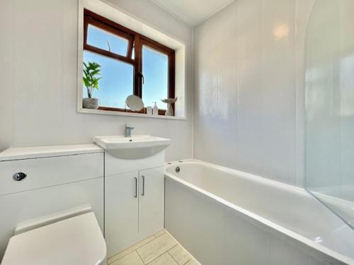 a bathroom with a sink and a toilet and a bath tub at Paddy Whack -A short stroll to Brixham Harbour in Brixham