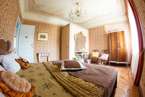 Un dormitorio con una cama grande y una lámpara de araña. en Villa Delbia - L'Elfo, en Candelo