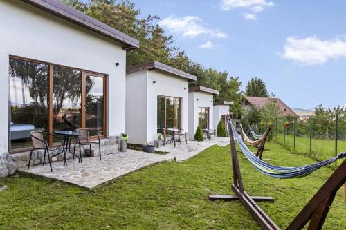 a backyard with a hammock and a house at Silver Bungalow in Săcele