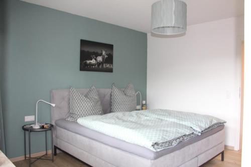 1 dormitorio con 1 cama con pared azul en Waldblick en Baiersbronn