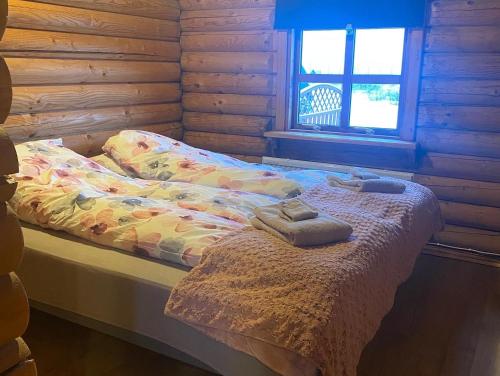Una cama en una cabaña de madera con dos toallas. en Cosy cabin with amazing view on the Geysir en Blaskogabyggo