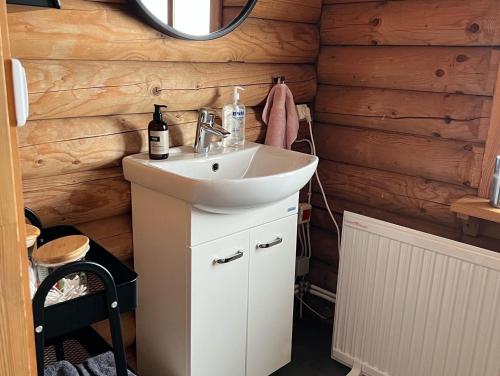 a bathroom with a sink and a mirror at Cosy cabin with amazing view on the Geysir in Blaskogabyggd
