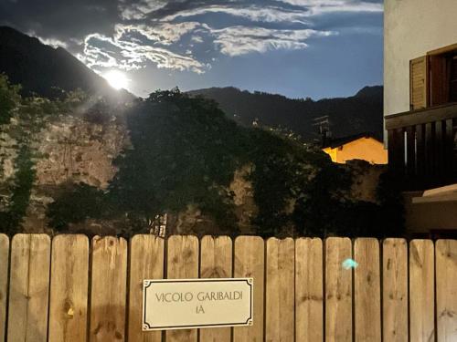 un panneau sur une clôture devant une montagne dans l'établissement SecretGarden - Levico Terme, à Levico Terme