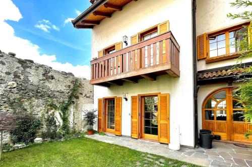 a house with wooden doors and a balcony at SecretGarden - Levico Terme in Levico Terme