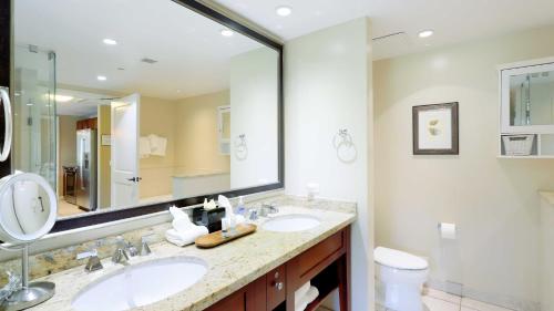 a bathroom with two sinks and a large mirror at Honua Kai - Hokulani 414 in Lahaina