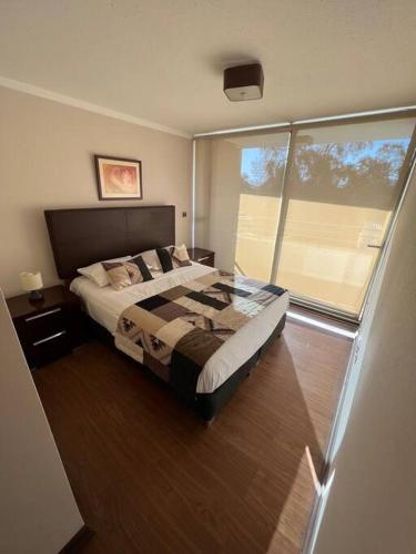 1 dormitorio con cama y ventana grande en Departamento 2P 2B para 4 personas By Terrabahía en Copiapó